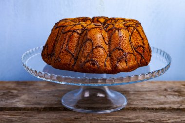 Üzerinde mavi bir arka plan şeffaf bir tabak lezzetli çikolatalı kek