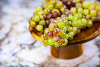 Üzüm mermer bir tabloda bir ahşap kase.