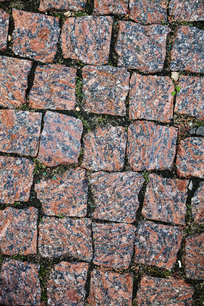 Stone road close up. Fragment of a walkway in the park.