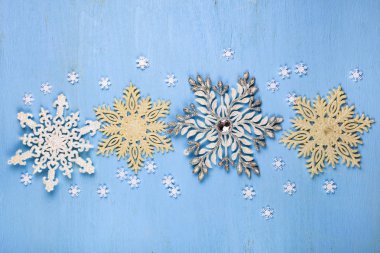 Mavi ahşap arka plan üzerinde Noel kar taneleri.