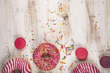 Çörek ve macaroons ahşap arka plan üzerinde. Lezzetli tatlı.