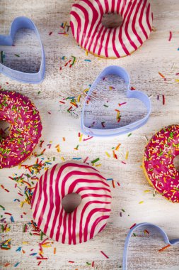 Çörek ve bir ahşap zemin üzerinde mavi kalpler. Lezzetli tatlı.