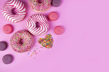 Çörek, Bademli kurabiye ve pasta ve şekerlemeler kalp pembe bir arka plan üzerinde. Lezzetli tatlı.