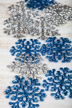 Ahşap bir zemin üzerine mavi ve gümüş kar tanesi. Noel dekor.