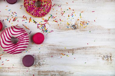 Çörek ve macaroons ahşap arka plan üzerinde. Lezzetli tatlı.