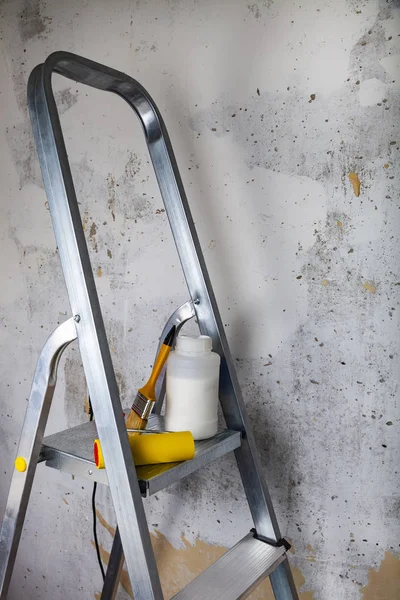 塗料や脚立の上のブラシ 灰色の壁に対して家またはオフィスの改装工事のためのアイテム — ストック写真