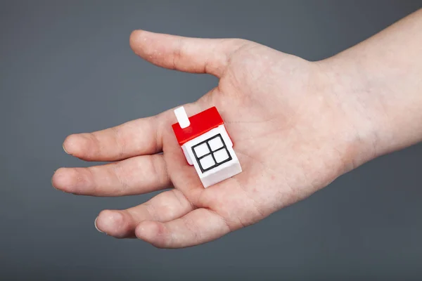 Man Holds Small House Hand Gray Background Buying Selling Real — Stock Photo, Image