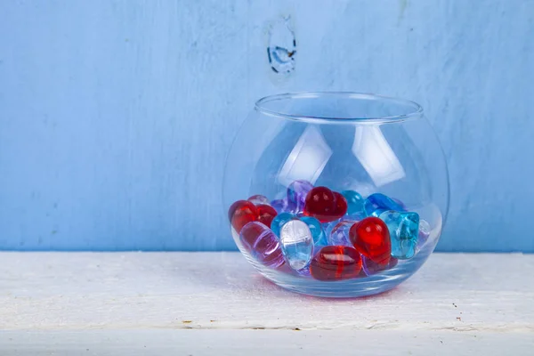 Mehrfarbige Glasherzen Einer Runden Vase Auf Blauem Hintergrund — Stockfoto