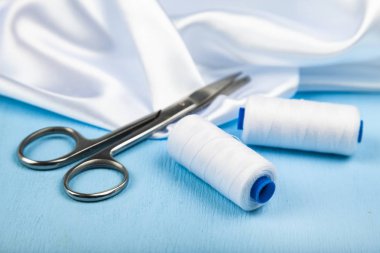 Mavi ahşap arka plan üzerinde dikiş aksesuarları.