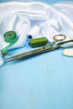 Mavi ahşap arka plan üzerinde dikiş aksesuarları.