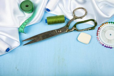 Mavi ahşap arka plan üzerinde dikiş aksesuarları.