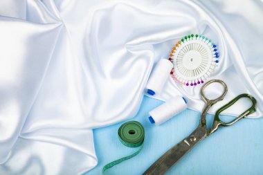 Mavi ahşap arka plan üzerinde dikiş aksesuarları.