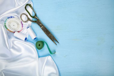 Mavi ahşap arka plan üzerinde dikiş aksesuarları.