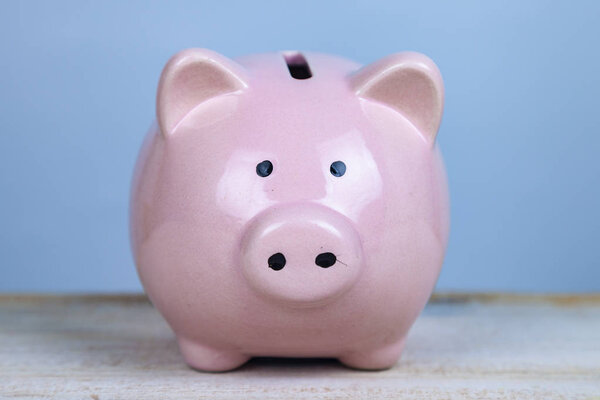 Pink pig money box on a wooden background