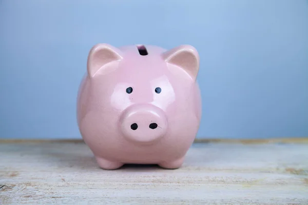 Pink pig money box on a wooden background