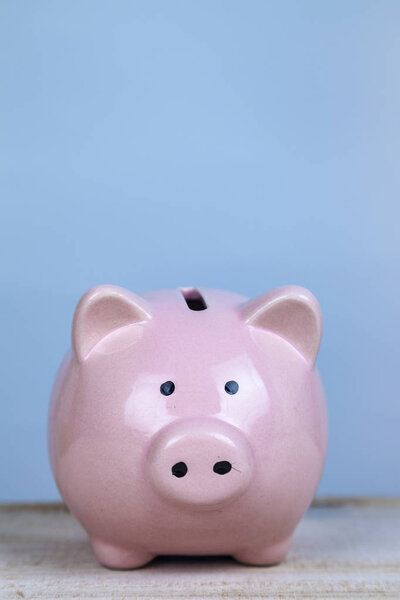 Pink pig money box on a wooden background