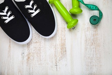 Spor ayakkabılar, halterler ve ölçüm bandı 