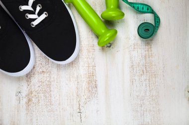 Spor ayakkabılar, halterler ve ölçüm bandı 