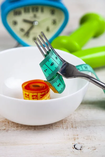 Fork, plate, measuring tape and dumbbells — Stock Photo, Image