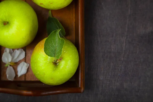 Grüne Äpfel auf einem Holztablett. — Stockfoto