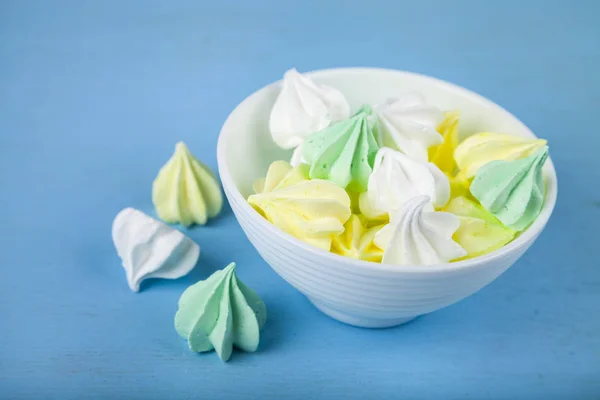 Baiser in weißer Schale auf blauem Hintergrund — Stockfoto