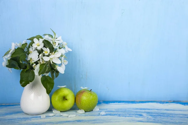 Boeket van bloemen in een vaas en groene appels — Stockfoto