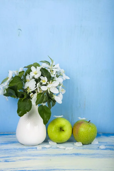 Blumenstrauß in einer Vase und grüne Äpfel — Stockfoto