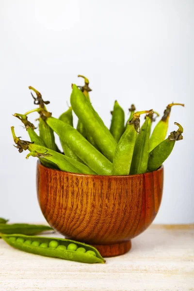 Groene erwten in een houten schaal. — Stockfoto