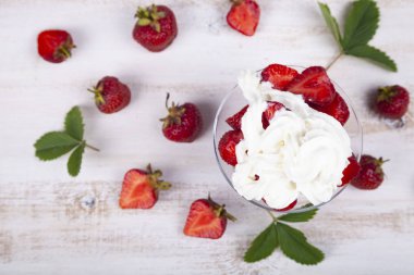 Şeffaf bir kapta çilek ve krema.