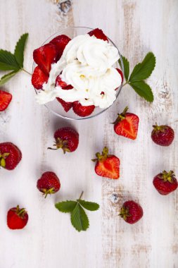 Şeffaf bir kapta çilek ve krema 