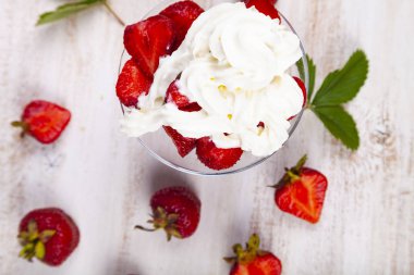 Şeffaf bir kapta çilek ve krema 