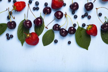 Mavi ahşap arka plan üzerinde olgun çilek.