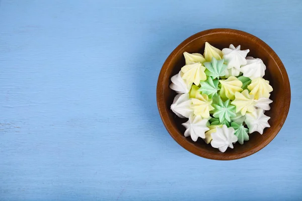 Meringue in een kom op een blauwe houten achtergrond, — Stockfoto