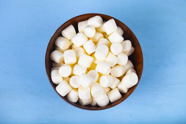 Mavi ahşap arka plan üzerinde bir kase marshmallow — Stok fotoğraf