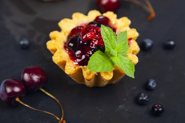 Pastel pequeño de bayas, cereza dulce, arándanos y menta — Foto de Stock