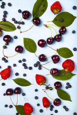 Mavi ahşap arka plan üzerinde olgun çilek.