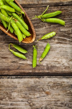 Tahta bir kasede yeşil bezelyeler. 