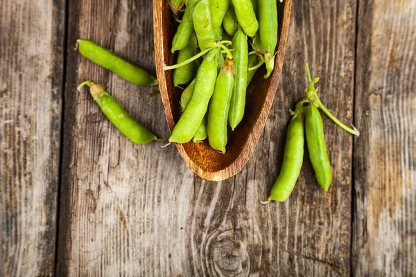 Groene erwten in een houten schaal. — Stockfoto