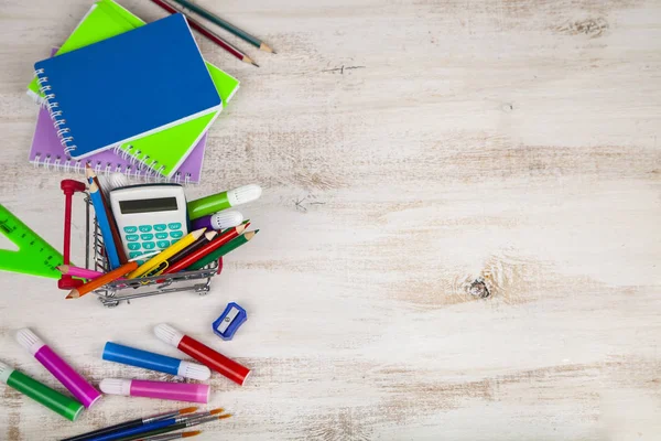 Items voor school in een winkelwagentje. — Stockfoto