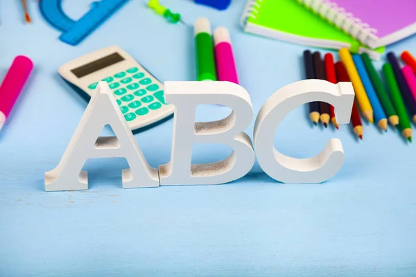 Przedmioty do szkoły i litery ABC na drewnianym stole. — Zdjęcie stockowe
