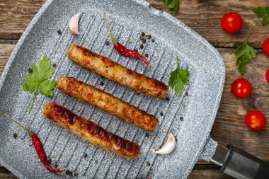 Bir tavada Kupaty, sebze ve baharatlar.