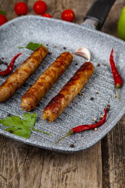 Bir tavada Kupaty, sebze ve baharatlar.