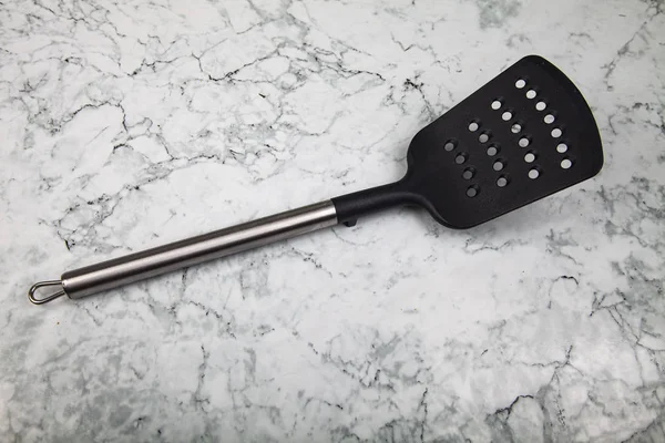 Kitchen spatula on a marble table. — Stock Photo, Image