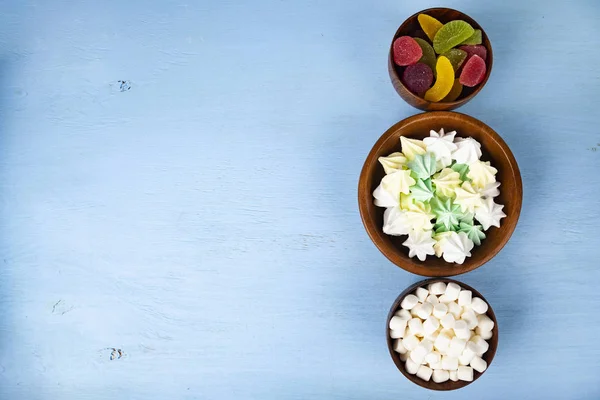 Merengue, marmelada e marshmallow em tigelas de madeira — Fotografia de Stock