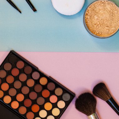 Pembe-mavi arka planda kozmetik ve fırçalar. Dekoratif kozmetik.