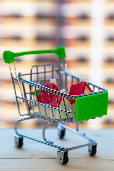 Haus Einem Einkaufswagen Auf Dem Hintergrund Eines Bau Befindlichen Gebäudes — Stockfoto