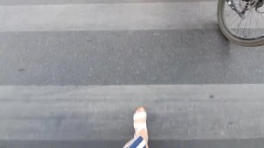 Kadın bir zebrayla karşıdan karşıya geçiyor.