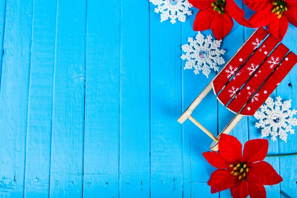 Bodegón Navidad Trineos Copos Nieve Poinsettia Sobre Fondo Madera Azul —  Fotos de Stock