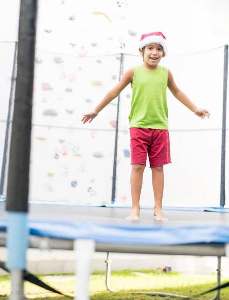 Jongetje Met Kerstmuts Springen Trampoline — Stockfoto