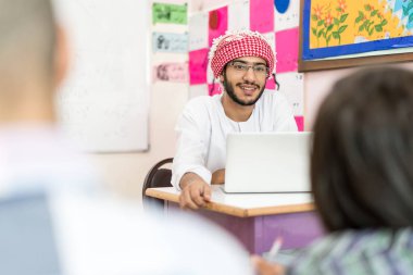 Müslüman öğretmen ile okul sınıfında çocuk